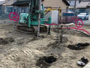 地盤改良工事中の現場状況。改良体施工機と配管、掘削穴の位置関係を確認できる写真（人物の写り込み部分は加工済み）